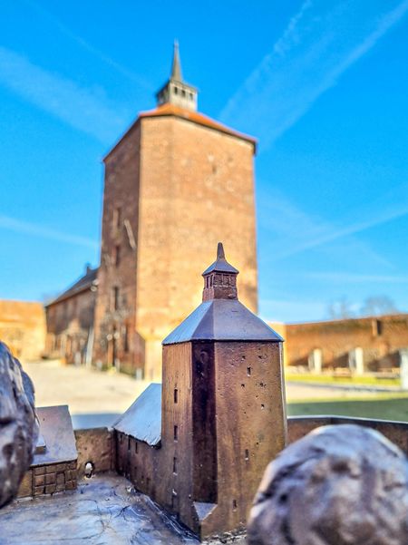 Blick auf ein Miniatur-Modell des Burgfrieds mit Blick auf den echten Burgfried im Hintergrund.