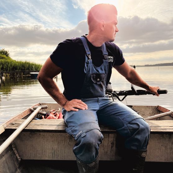 Der Fischer Sander sitzt im Boot und fährt über die Groß Schauener Seenkette.