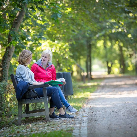 Zwei Frauen sitzen auf einer Bank 