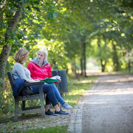 Zwei Frauen sitzen auf einer Bank 