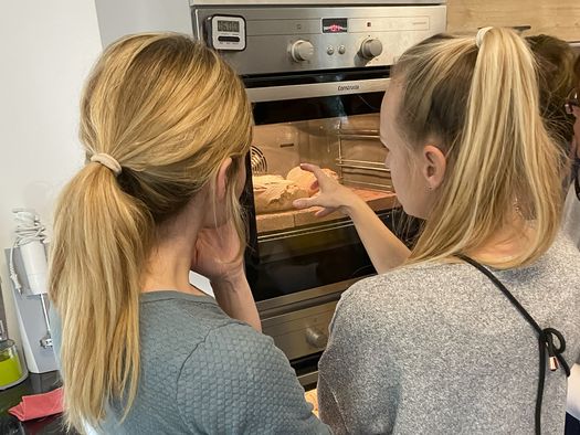 Zwei Frauen schauen auf das Brot im Ofen