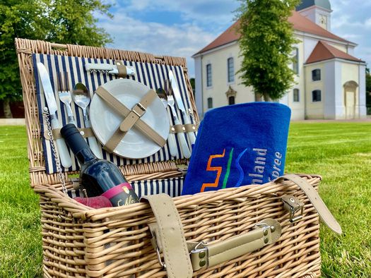 Picknickkorb auf dem Schlossgut in Altlandsberg steht auf der grünen Wiese