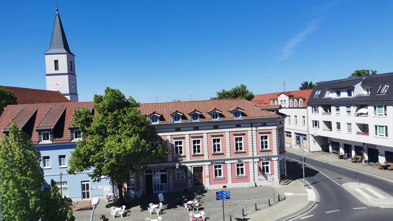 Blick auf den Marktplatz von Seelow, wo ein Café Außenplätze errichtet hat mit Blick auf die Kirche