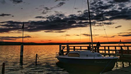 Segelboot bei Sonnenuntergang am Steg des Scharmützelsees