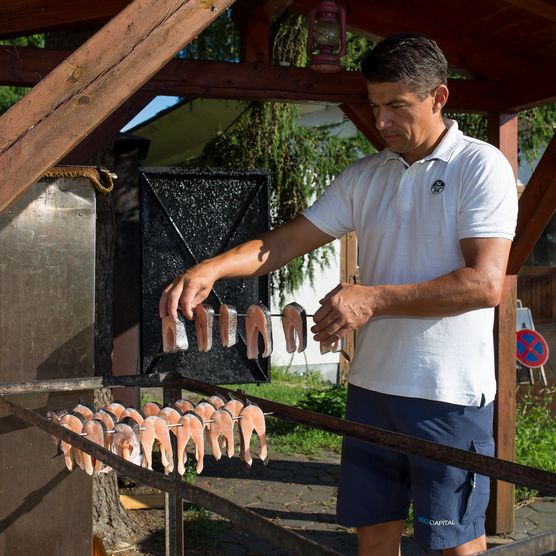 Gastronom hÃ¤lt den gerÃ¤ucherten Fisch in den Händen im Fischland Scharmützelsee in Wendisch Rietz 