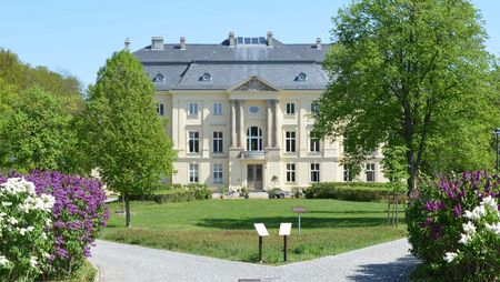 Vorderansicht Schloss Trebnitz mit Blumen und Bäumen 