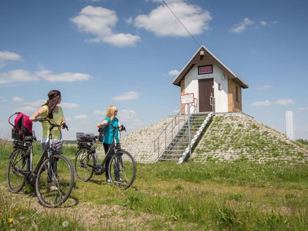 Radfahrerinnen vor dem Pegelhäuschen in Ratzdorf am Oder-Neiße-Radweg