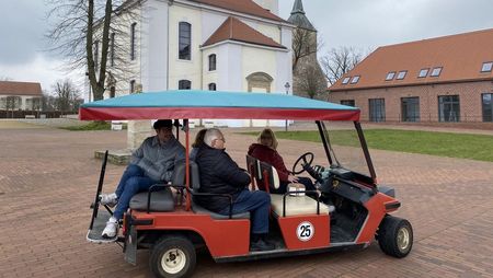 Vier Personen sitzen im Golfcar