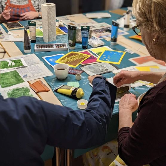 Die Teilnehmenden des Workshops "Kreativ-Druck" üben die Drucktechnik "Monotypie"