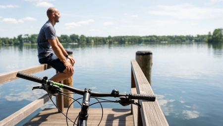 Fahrradfahrer am Steg am Wasser