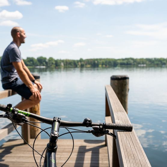 Fahrradfahrer am Steg am Wasser