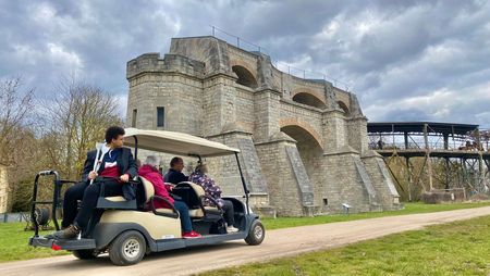 Menschen fahren mit Golfcar im Museumspark Rüdersdorf