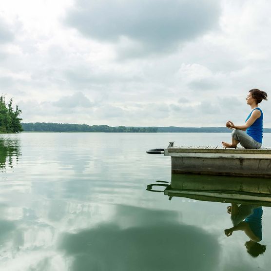 Eine Frau macht Yoga auf einem Steg am Scharmützelsee