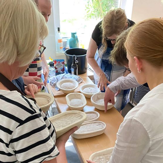 Vier Menschen backen Brot