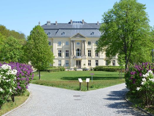 Vorderansicht Schloss Trebnitz mit Blumen und Bäumen 